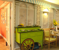 Wallpaper mural of a Cafe designed for dementia care homes featuring a market barrow with finger food